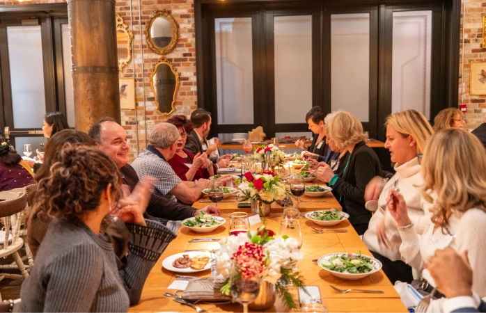 Guests sharing a meal at a long dinner table