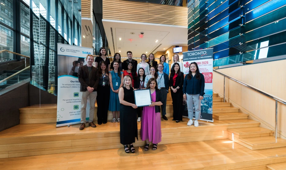 A group of people posing with an award on wide stairs
