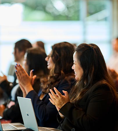 Audience members applauding during a conference session