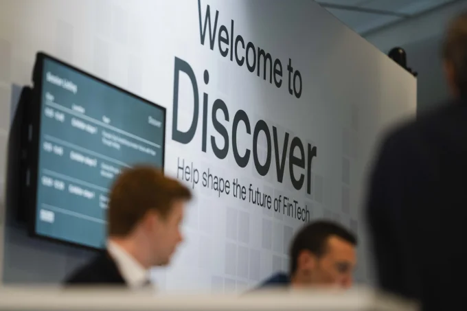 Attendees walking past a Welcome to Discover sign at a conference