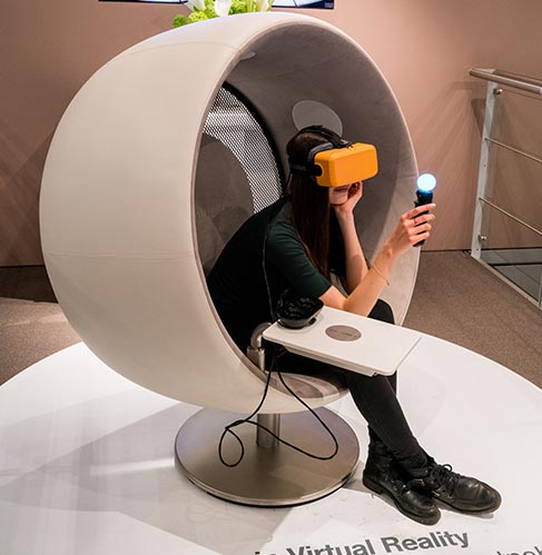 A person in a virtual reality chair, wearing a headset