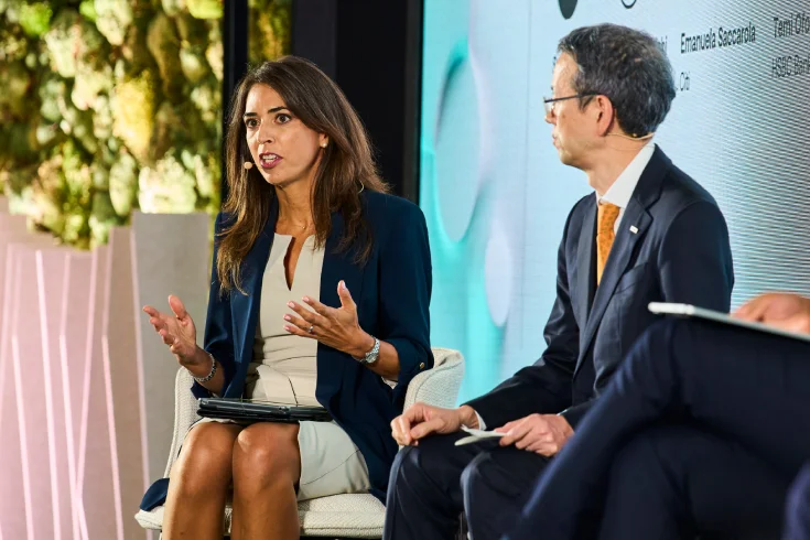 A woman and a man speaking on stage during a panel discussion