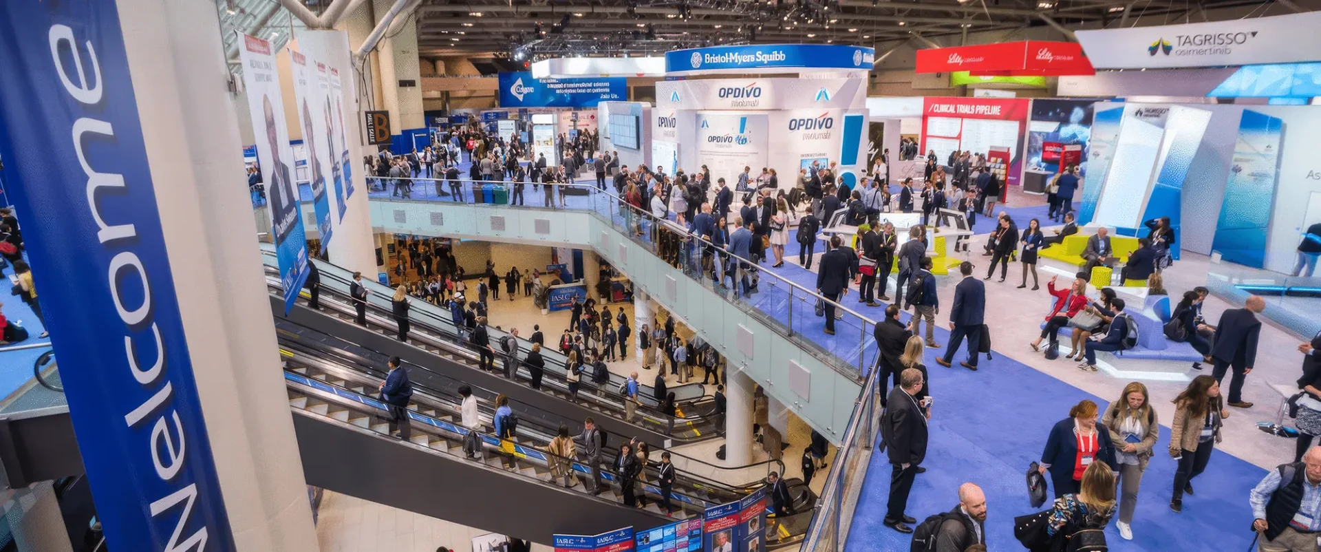 A busy convention centre atrium with a Welcome sign