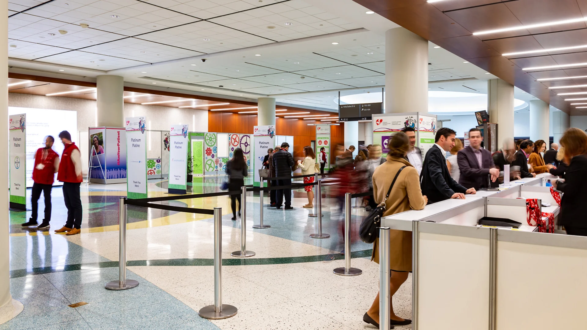 Visitors at registration desks in a bright conference hall