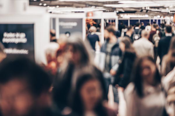 A crowd of attendees moving through a busy conference hall