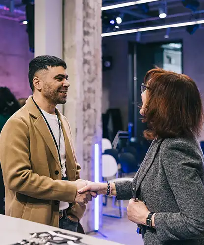 Two people shaking hands at a conference