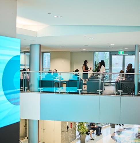 Attendees walking past glass walls inside a convention centre
