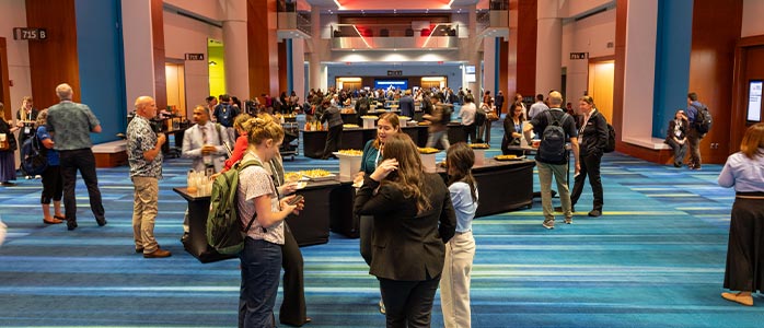 A busy conference hall with attendees between booths