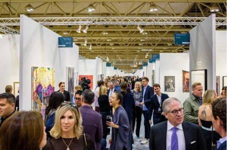 Visitors walking through a busy art fair