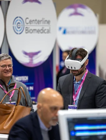 A visitor trying a virtual reality headset at a medical technology booth