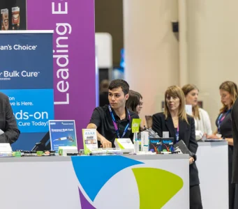 Exhibitors talking with visitors at a booth during a medical congress