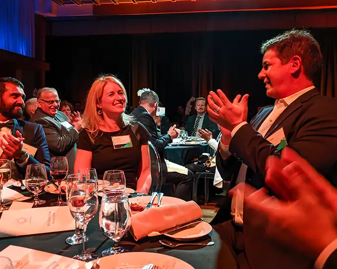 Guests laughing together at a dinner event