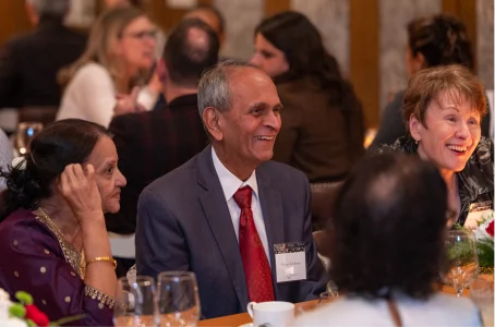 Guests smiling at a dinner table during an evening event
