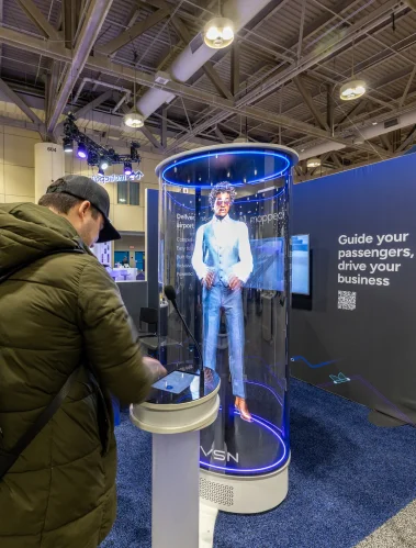 A visitor looking at a hologram display in a glass booth