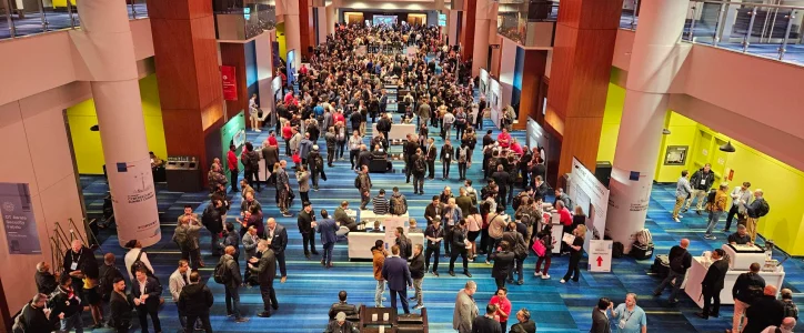 A crowd in a large convention centre hall during an exhibition