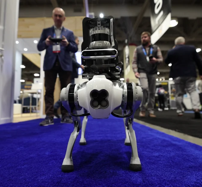 A robot dog on a blue carpet at a technology exhibition