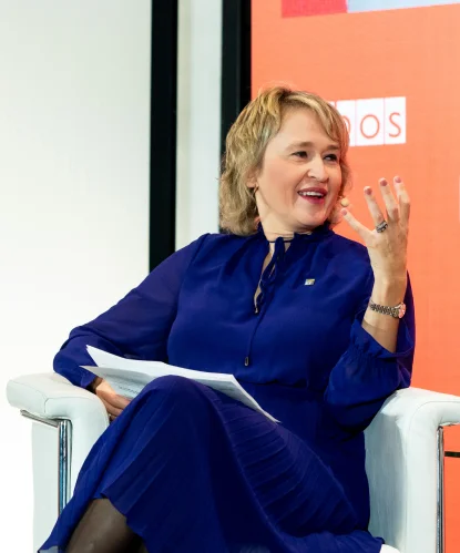 A woman in a blue dress speaking on stage