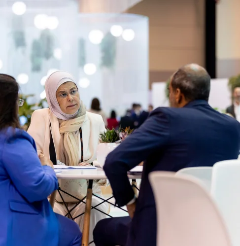 Two women talking at a table in an exhibition hall