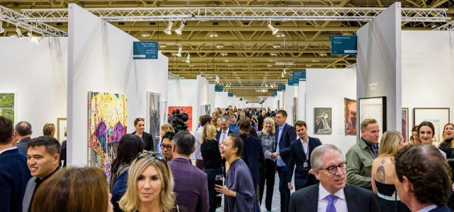 Visitors walking through a busy art fair