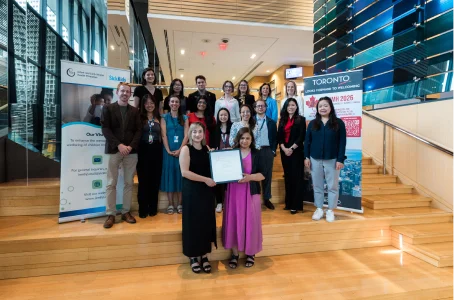A group of people posing with an award on wide stairs