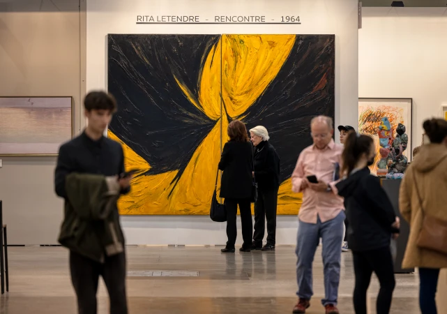 Visitors looking at a large painting at an art fair
