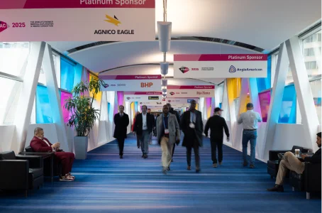 Attendees walking down a long, colourful conference hallway