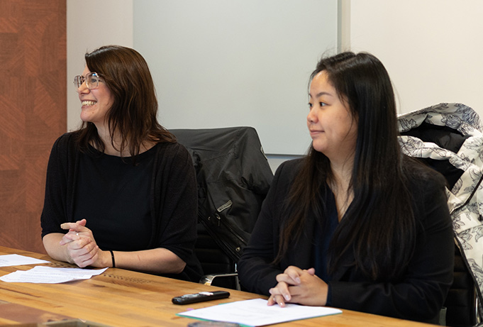 Two women smiling at a meeting table