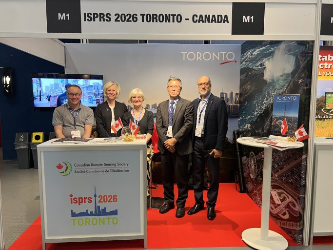 Conference representatives gathered beside an exhibition display at an international congress.