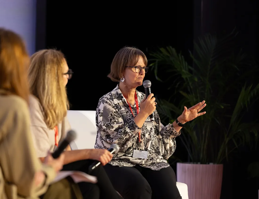 Speakers seated on stage participating in an arts and culture panel discussion.