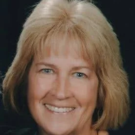 Portrait of Kathryn McManus smiling with shoulder-length blonde hair.